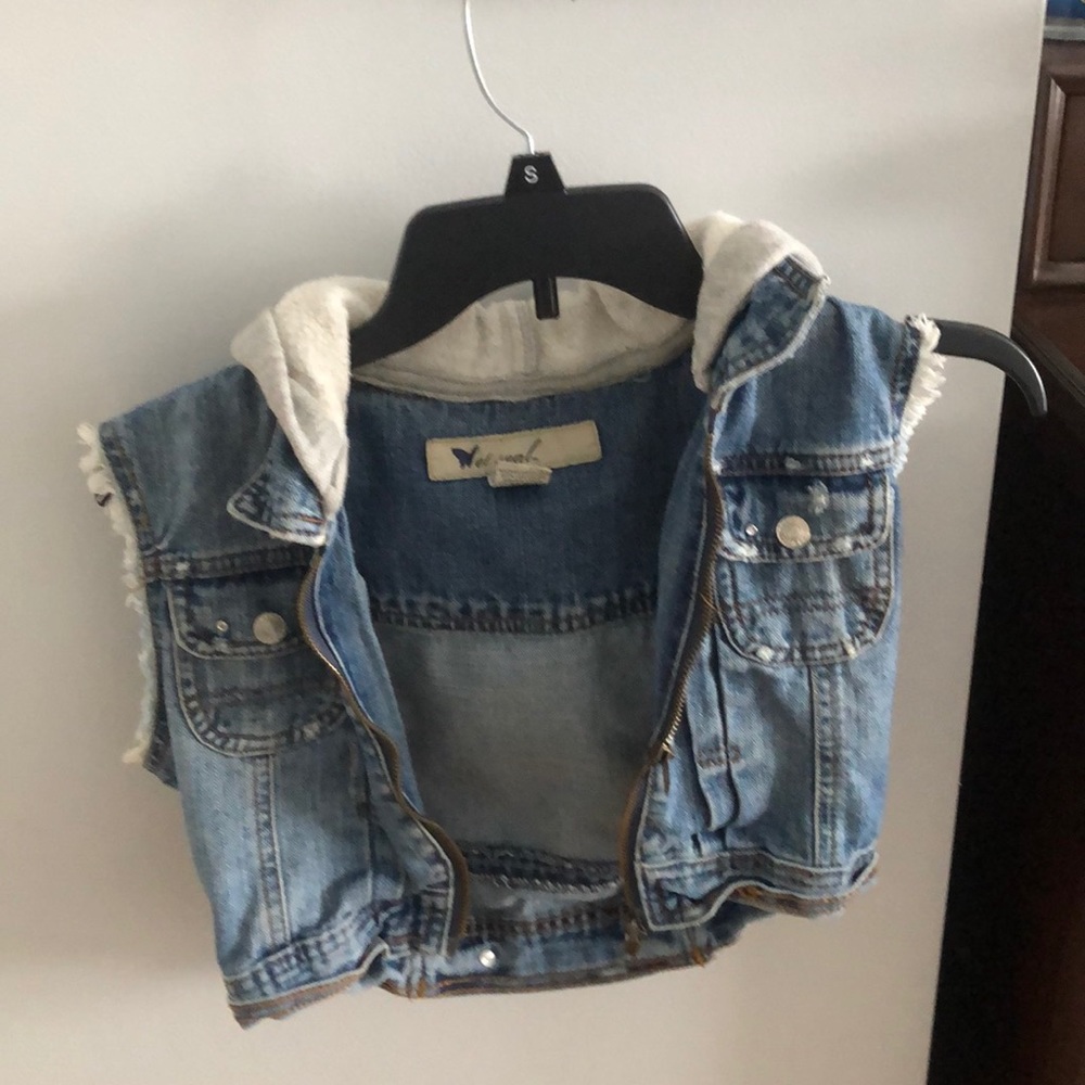 a cropped sleeveless jean jacket